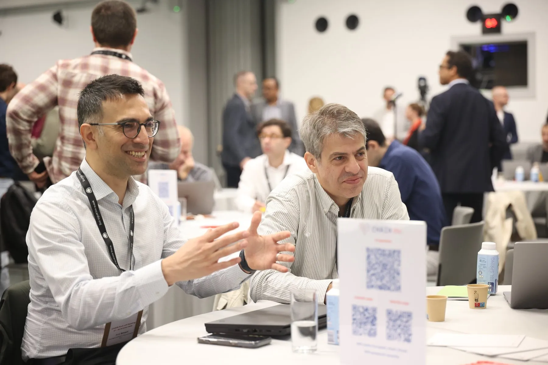 Two participants in discussion at a table during the CHAIN kick-off meeting